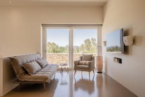 a living room with a couch and a chair and a window at Luxury Villa Gialova Neokastro with Private Pool in Gialova