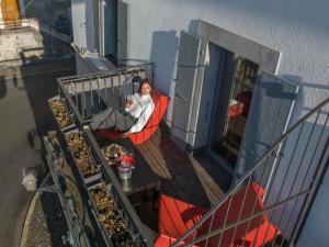 una mujer sentada en una silla en un balcón en Tralala Hotel Montreux, en Montreux