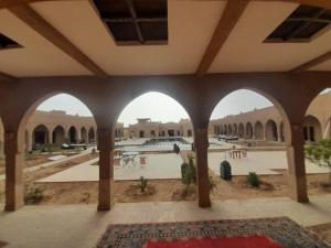 a view from the courtyard of a building with arches at Kasr Tin Hinane in Merzouga