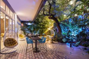 um pátio com cadeiras, mesas, árvores e luzes em Atwell Suites - Miami Brickell, an IHG Hotel em Miami