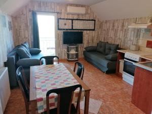 sala de estar con mesa y sofá en A nyugalom szigete Tabán Apartman, en Dunakeszi