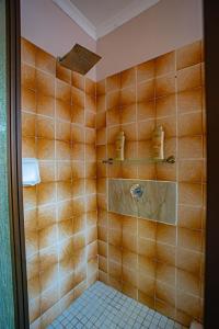 a bathroom with a shower with a tiled wall at Homes of Ace 3 bedroom Villa in Pretoria