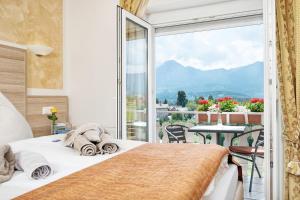 a bedroom with a bed and a large window at Hotel-Pension Melcher in Drobollach am Faakersee