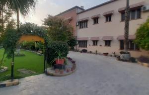 a courtyard with a building and a yard with plants at Spinghar Royal Hotel in Jalalabad 