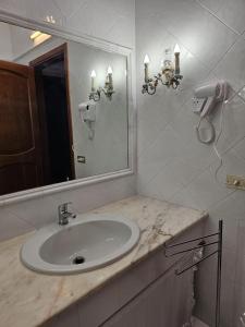 uma casa de banho com um lavatório e um espelho em RockSea Rooms em Cefalù