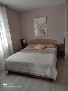 Un dormitorio con una cama con un cuadro en la pared. en Lavanda & limone, en Koper