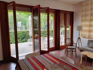 a bedroom with a bed and a living room with sliding glass doors at Villa Lilly in Grado