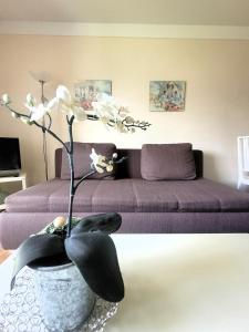 uma sala de estar com um sofá e um vaso com flores em Winterberg Appartement 21115 em Winterberg