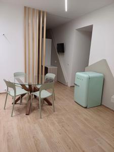 ein Esszimmer mit einem Tisch und Stühlen sowie einem kleinen Kühlschrank in der Unterkunft Appartamento Nonna Lina in Custonaci