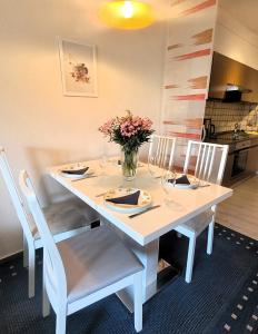 uma mesa branca com cadeiras e um vaso de flores em Winterberg Appartement 21115 em Winterberg