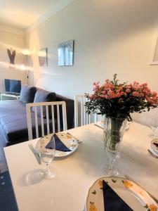 una mesa con platos y un jarrón de flores. en Winterberg Appartement 21115, en Winterberg