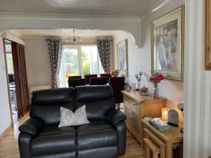 a living room with a leather couch and a dining room at 3bedroom 1bathroom 1 shower room in quiet area in Inverness