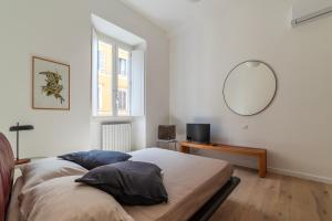 Schlafzimmer mit einem Bett und einem Spiegel an der Wand in der Unterkunft Termini & Acquario Romano Bright Apartment in Rom