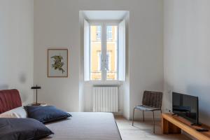 a bedroom with a bed and a tv and a window at Termini & Acquario Romano Bright Apartment in Rome