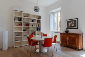 a dining room with a table and red chairs at Termini & Acquario Romano Bright Apartment in Rome