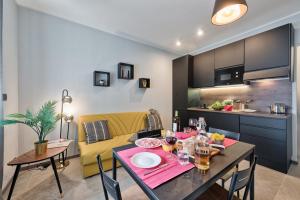 a dining room and kitchen with a table and a yellow couch at Casa RIGOLA by Apartments To Art in Venaria Reale +15 photos
