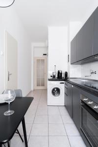 a kitchen with a table and a washing machine at Contemporary Flat in New Town by Prague Days in Prague
