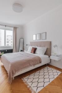 a white bedroom with a large bed and a rug at Contemporary Flat in New Town by Prague Days in Prague