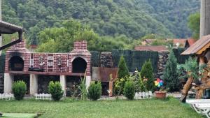 a garden with a brick house in the yard at New Cabana Beea in Dubova