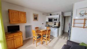 a small kitchen with a table and a small kitchen with a kitchen at Studio 4 personnes in Font-Romeu-Odeillo-Via