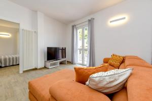 a living room with a couch and a television at Tre passi dal lago 2 in Toscolano Maderno