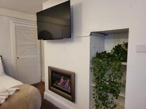 a room with a fireplace with a tv on a wall at Seaside Flat with Fast WiFi in Scarborough