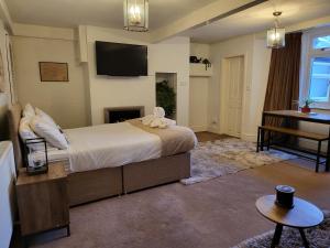 a bedroom with a bed and a desk and a television at Seaside Flat with Fast WiFi in Scarborough