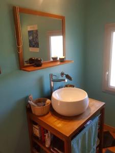 a bathroom with a sink and a mirror on a table at Maison spacieuse face aux Pyrénées in Carla-Bayle