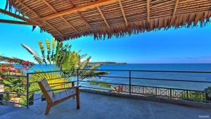 un banco sentado en un balcón con vistas al océano en Superbe villa avec ponton privé, en Andilana