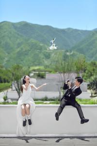 uma estatueta de plástico de um homem a tirar uma fotografia a uma mulher em Yuncheng Yunxi Furusato-Banma Resort em Yuncheng