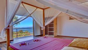 ein Schlafzimmer mit einem großen Bett mit Blumen darauf in der Unterkunft Superbe villa avec ponton privé in Andilana