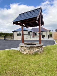 un pabellón con techo solar sobre un campo de césped en NEW - The Gate Lodge at Dunnanew - 4 star- Sleeps 5 en Seaforde