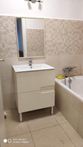 a bathroom with a sink and a tub and a mirror at Hostal Estudios in Badalona