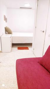 a bedroom with a bed and a red rug at Hostal Estudios in Badalona