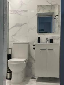 a white bathroom with a toilet and a sink at Casa Luna IV tu oasis en Madrid in Madrid