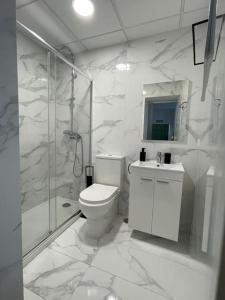 a white bathroom with a toilet and a shower at Casa Luna IV tu oasis en Madrid in Madrid
