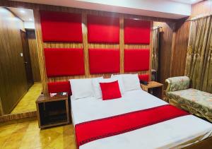 a bedroom with a large bed with a red headboard at Sapphire Inn Motel Lahore in Lahore