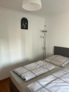 ein Schlafzimmer mit 2 Betten und einer Uhr an der Wand in der Unterkunft Zen und Modernes Apartment in Remscheid Zentrum in Remscheid