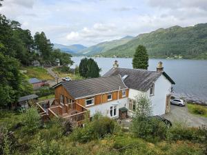 una casa grande a orillas de un lago en Lochwood Guest House Wing, en Lochgoilhead