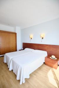 a bedroom with a large white bed with a wooden headboard at JS Ca'n Picafort in Can Picafort