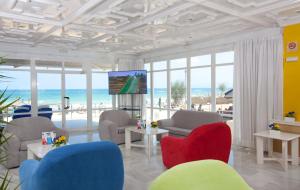 sala de estar con sillas y TV y la playa en JS Ca'n Picafort, en Can Picafort