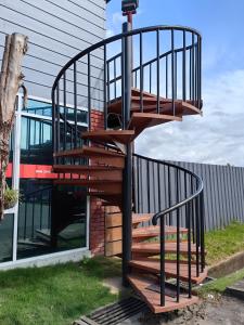 a wooden spiral staircase in front of a building at Grapevine Garden in Kota Kinabalu