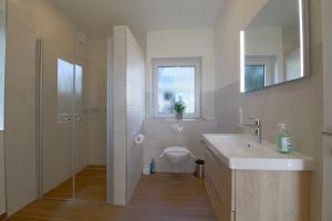 a bathroom with a toilet and a sink and a shower at KW6 Haus Weitblick in Dorum Neufeld