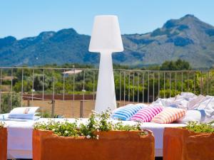 a table with pillows and a lamp on a balcony at Barcares Petit by BeBreeze Mallorca in Alcudia