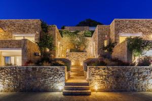 a stone building with stairs in front at night at Luxusvilla Lagoon 4 Personen privater Pool in Gialova