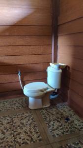 a toilet sitting next to a wooden wall at บ้านพักพือวา Pue Wa Homestay in Ban Yang