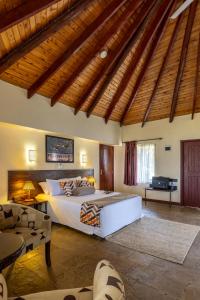 1 dormitorio con 1 cama grande y techo de madera en Sentrim Elementaita Lodge, en Elmenteita