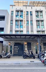 a group of scooters parked in front of a building at 週週客棧 in Chia-hsiu