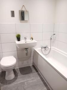 a bathroom with a toilet and a sink and a bath tub at Bliss Apartments - Contractor 314 in Bradford