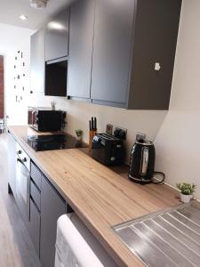 a kitchen with a wooden counter top in a room at Bliss Apartments - Contractor 314 in Bradford